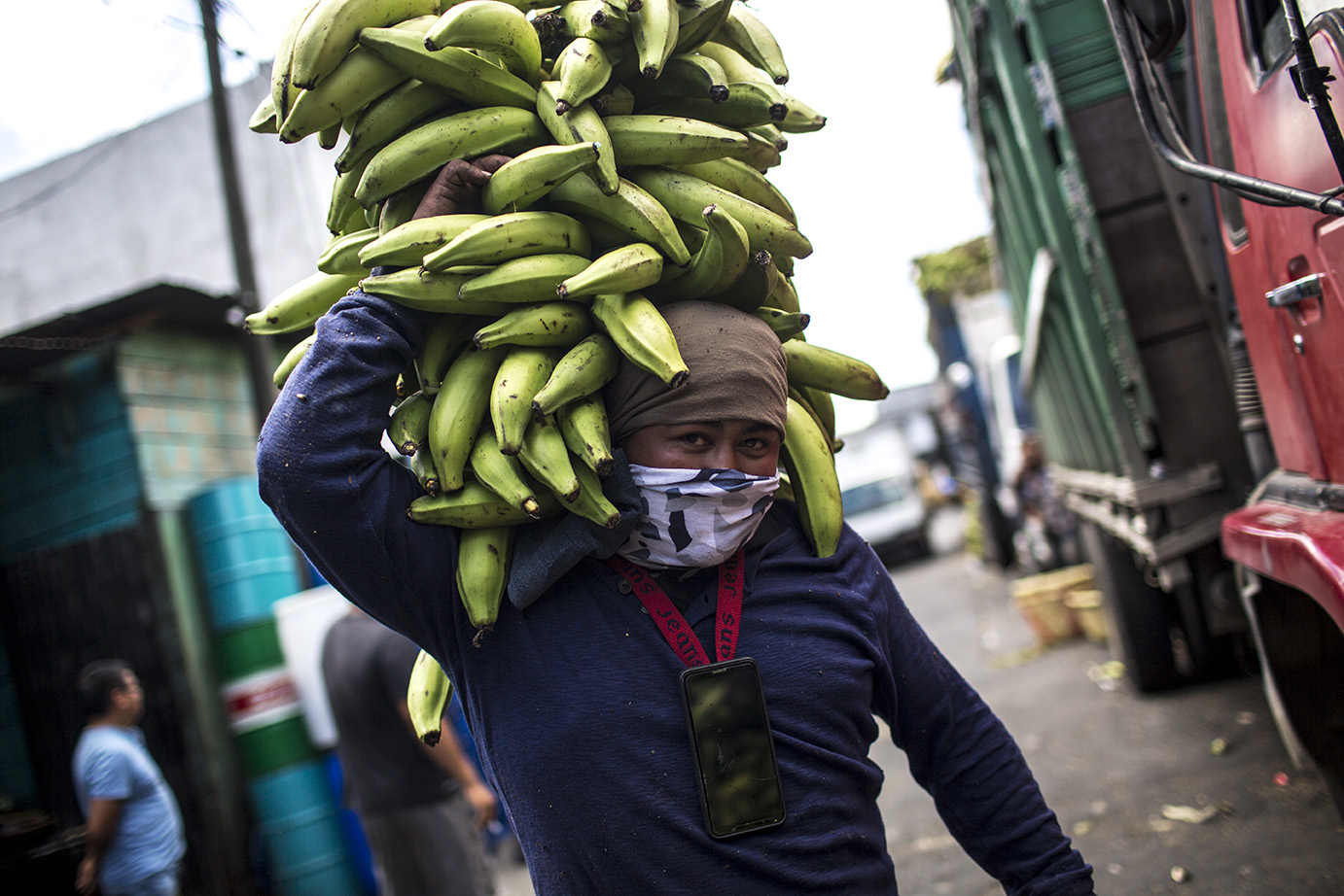 Ronald Quintero, 30, carga plátanos en la platanera del mercado de la Terminal, el miércoles 18. No puede dejar de trabajar y sigue ganando 1 quetzal por cada carga de plátanos transportada. Simone Dalmasso