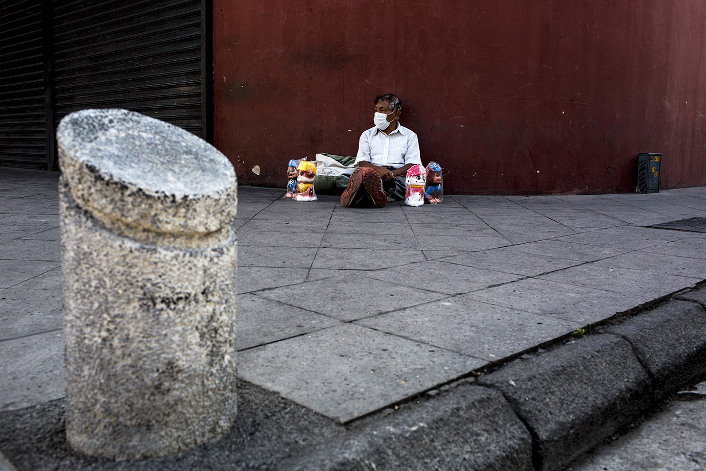 Don Pedro Ajanel, originario de Totonicapán, sienta al suelo rodeado de las alcancías que suele vender para alimentar a su familia a 20 quetzales cada una. El jueves 19 logró vender solamente una. Simone Dalmasso 