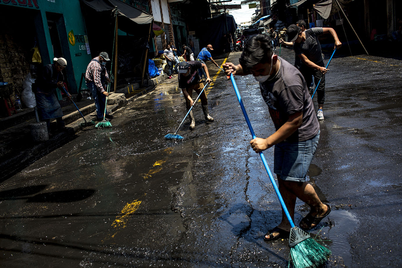 Vendedores de la carbonera, en el mercado de la Terminal, limpian voluntariamente la calle al mediodía del miércoles 18 como medida para prevenir el contagio. Simone Dalmasso