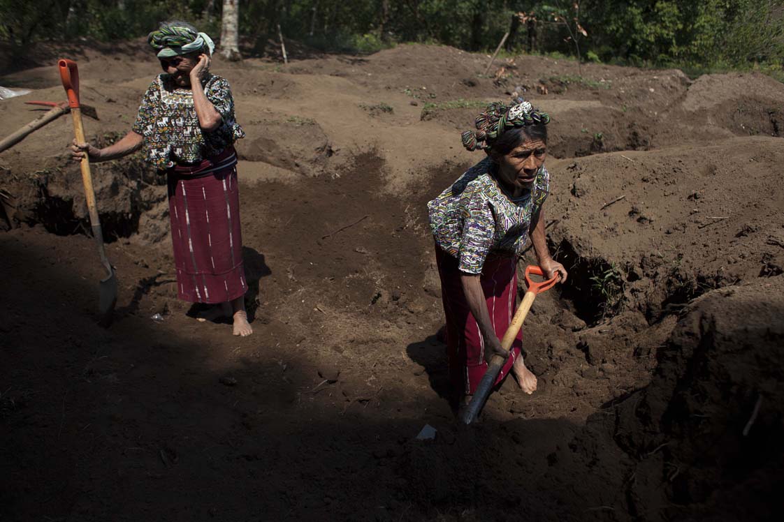 Descalzas, Feliciana y Catarina empiezan el día de trabajo, escavando fosas, en búsqueda de los restos de sus familiares.  