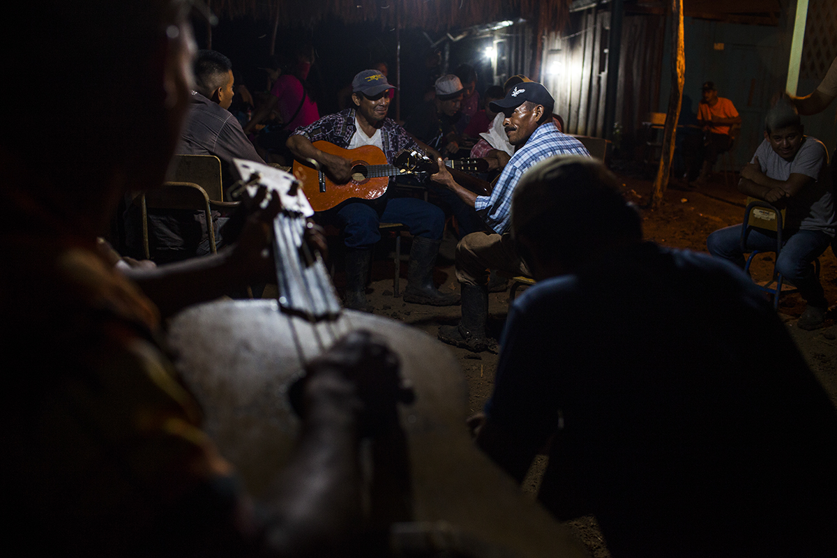 Los músicos suben el ánimo de la comunidad durante la noche de vigilia.