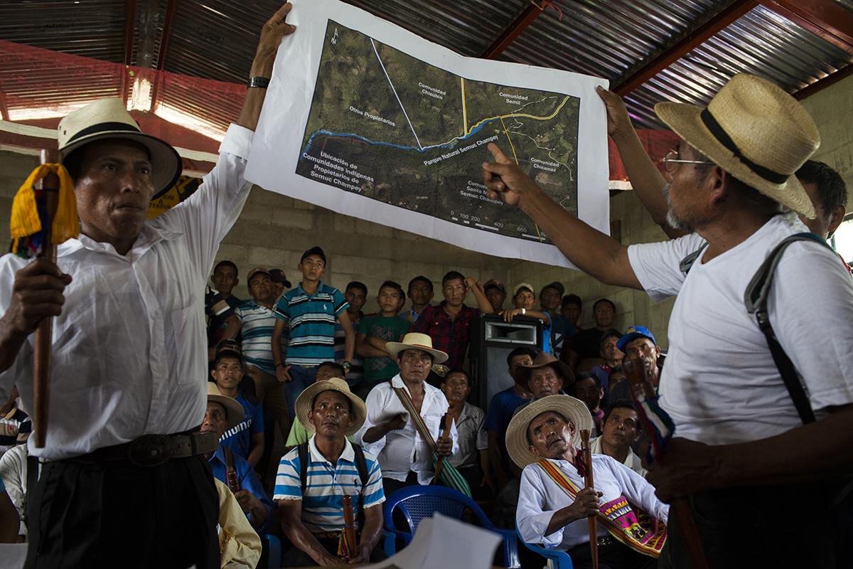Crisantos Asig Pop enseña el mapa de la región a los comunitarios, durante la reunión en Semil.