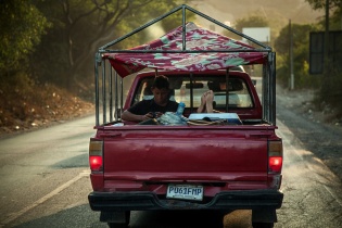 Dos jóvenes viajan en la trasera de un pick up a la altura de Guastatoya, El Progreso.